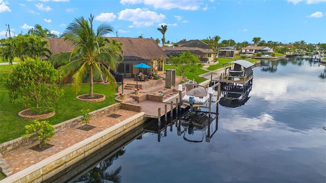 view of dock with a lanai, a yard, and a water view