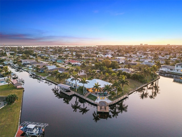 aerial view at dusk featuring a water view