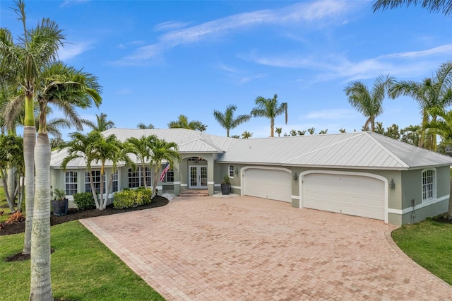 ranch-style house featuring a garage and french doors