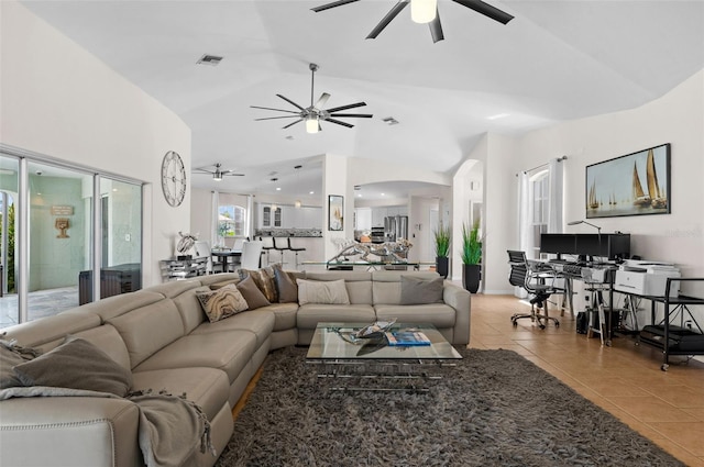 living room with ceiling fan, vaulted ceiling, and light tile patterned floors