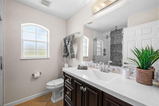 bathroom with vanity, a shower with shower door, tile patterned floors, and toilet