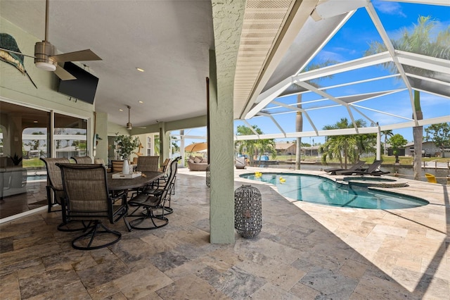 view of pool with an in ground hot tub, ceiling fan, a lanai, and a patio area