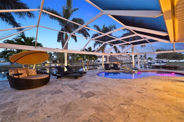 pool at dusk with a water view, a lanai, and a patio area