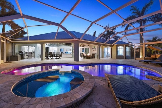 pool at dusk with a lanai, a patio, and an in ground hot tub