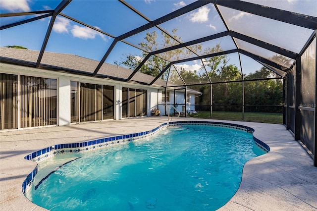 view of pool with a patio area and glass enclosure