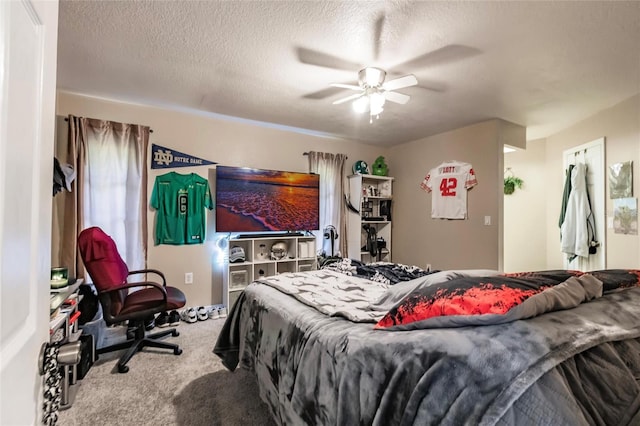 bedroom featuring ceiling fan, a textured ceiling, and carpet