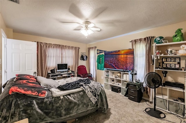 carpeted bedroom featuring ceiling fan and a textured ceiling