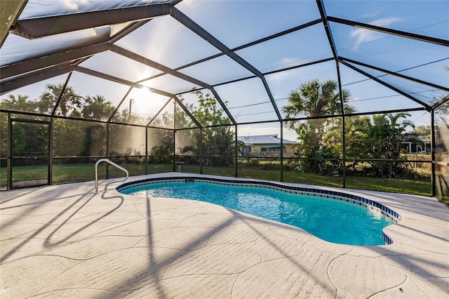 view of pool with glass enclosure and a patio area