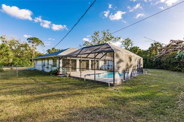 rear view of property featuring a yard and a lanai