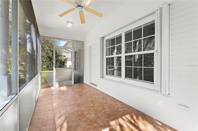 unfurnished sunroom with ceiling fan