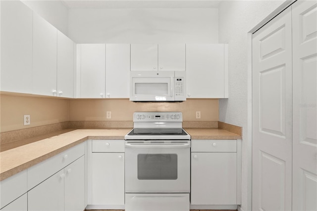 kitchen featuring white cabinetry and white appliances