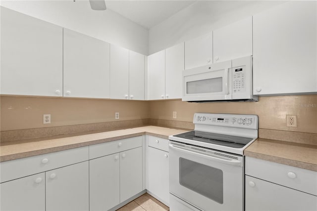 kitchen featuring white cabinetry, light tile patterned floors, and white appliances