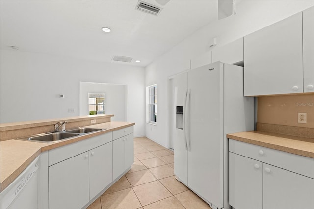 kitchen featuring white cabinetry, white appliances, light tile patterned flooring, and sink