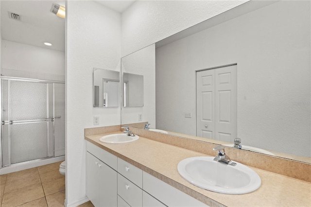 bathroom with vanity, tile patterned floors, toilet, and walk in shower