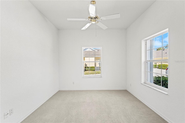 carpeted empty room with a wealth of natural light and ceiling fan