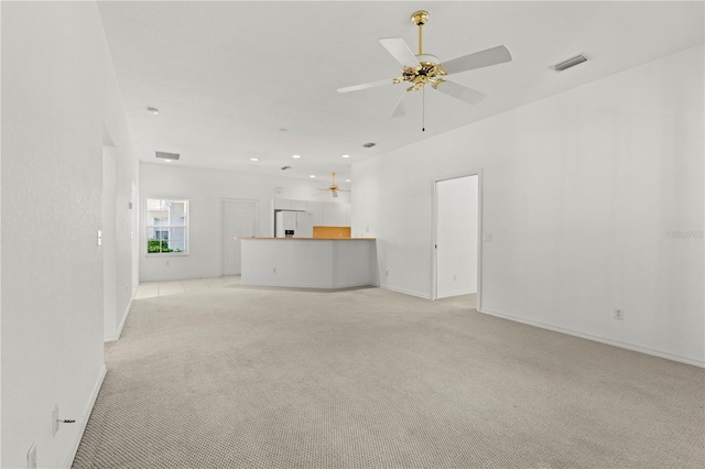 unfurnished living room featuring light colored carpet and ceiling fan