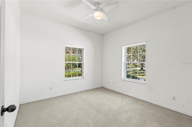 spare room featuring light colored carpet and ceiling fan