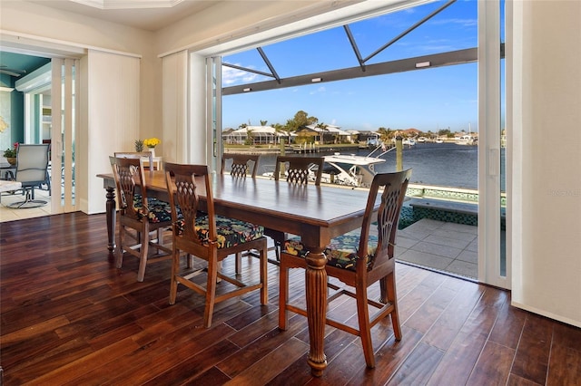 dining room featuring a water view and dark wood-type flooring