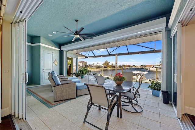 sunroom featuring a water view, plenty of natural light, and ceiling fan