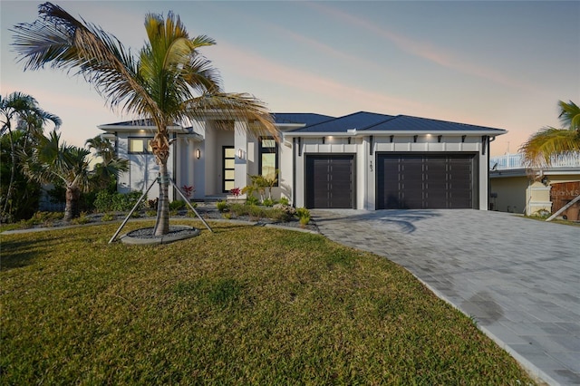 view of front of property featuring a garage and a yard