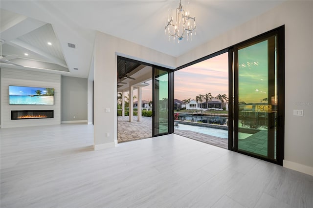 empty room featuring ceiling fan with notable chandelier