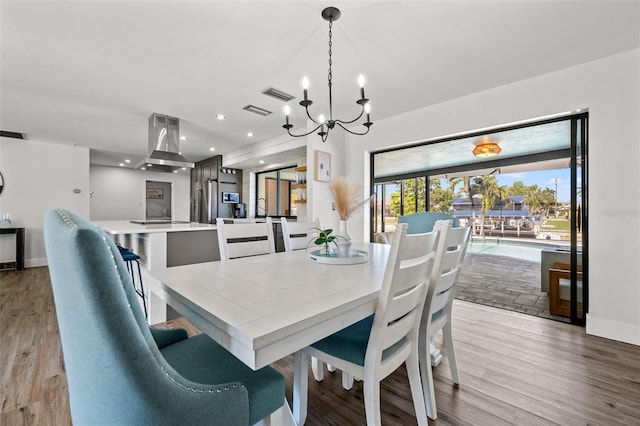 dining space with a notable chandelier and light hardwood / wood-style floors