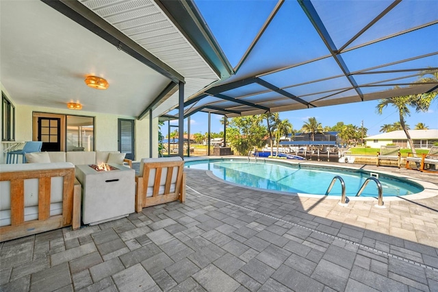 view of swimming pool featuring a patio, a lanai, and a fire pit