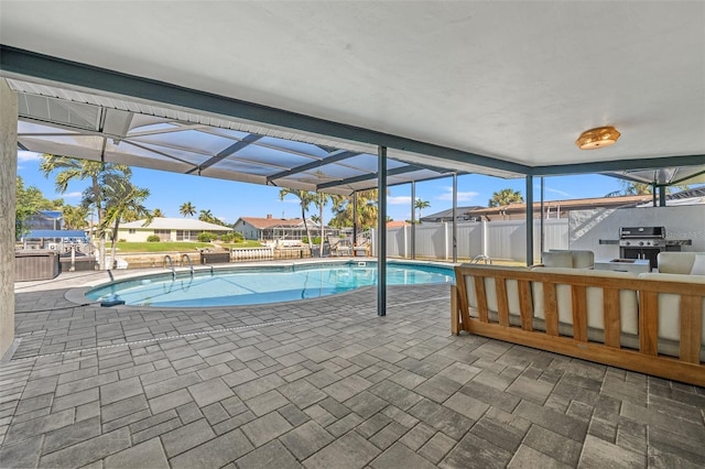 view of pool with area for grilling, a patio, outdoor lounge area, and glass enclosure