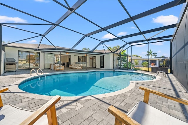 view of pool with a grill, a lanai, a patio area, and an outdoor living space