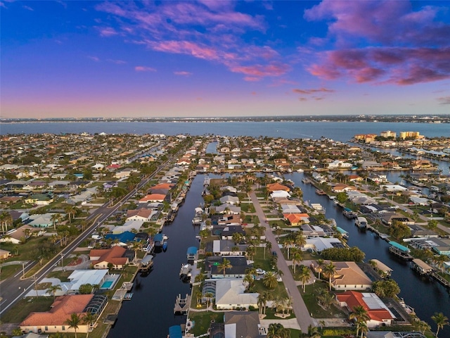 aerial view at dusk featuring a water view