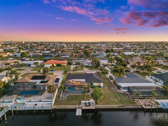 aerial view at dusk featuring a water view