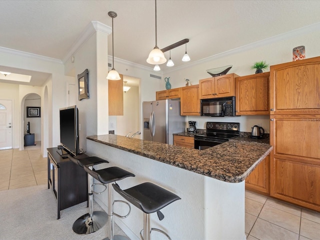 kitchen with decorative light fixtures, kitchen peninsula, light tile patterned floors, and black appliances