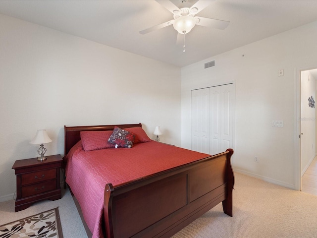 carpeted bedroom featuring ceiling fan and a closet