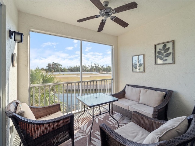 sunroom with a water view and ceiling fan