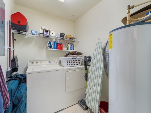 clothes washing area with water heater, washing machine and dryer, and light tile patterned floors