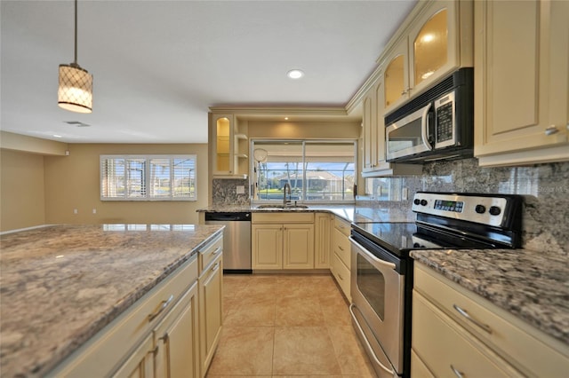 kitchen with sink, light stone counters, pendant lighting, stainless steel appliances, and backsplash