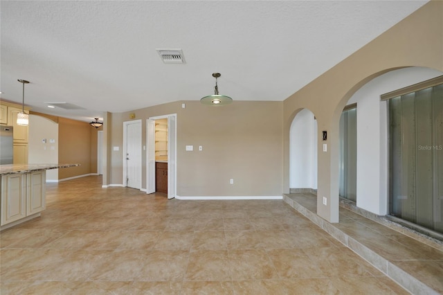 tiled spare room with a textured ceiling