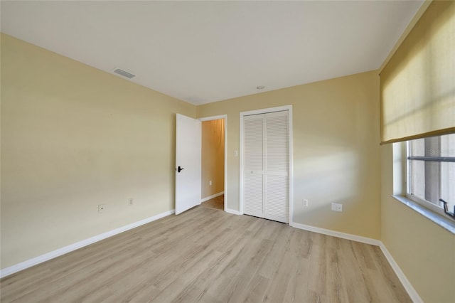 unfurnished bedroom featuring light hardwood / wood-style flooring and a closet