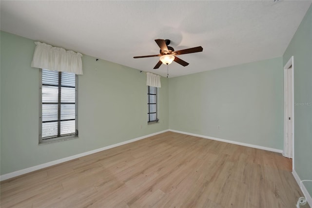 spare room with ceiling fan and light wood-type flooring