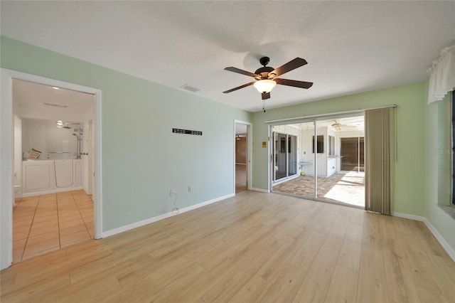 empty room featuring a textured ceiling, ceiling fan, and light wood-type flooring