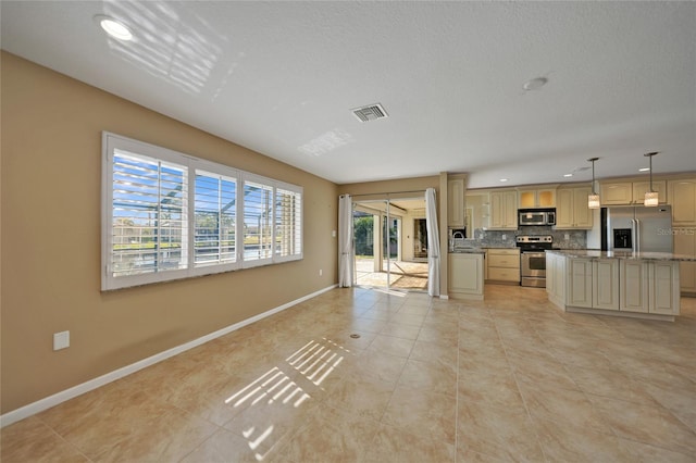 kitchen featuring appliances with stainless steel finishes, backsplash, a center island, light brown cabinetry, and decorative light fixtures