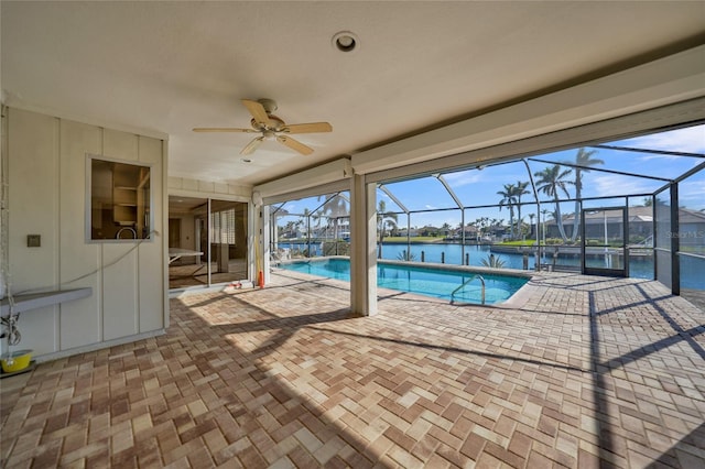 view of swimming pool with a water view and ceiling fan