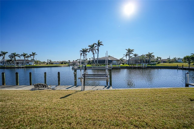 dock area with a water view and a yard