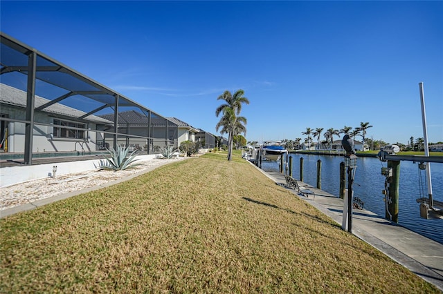 dock area featuring a yard, a lanai, and a water view