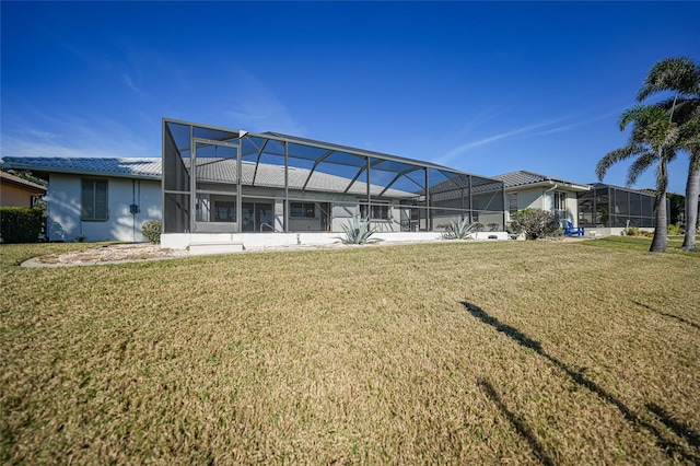 back of property with glass enclosure and a lawn