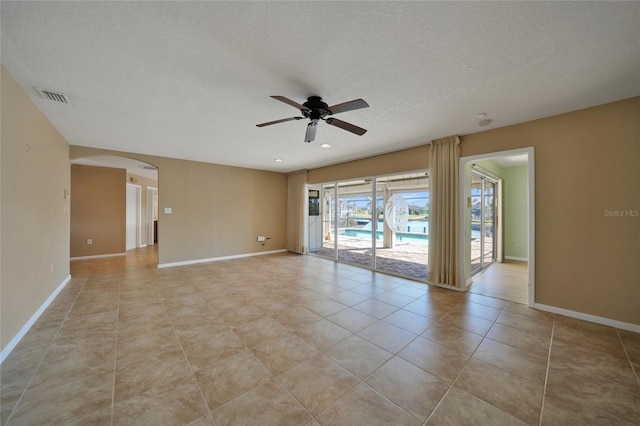 tiled empty room featuring a textured ceiling and ceiling fan