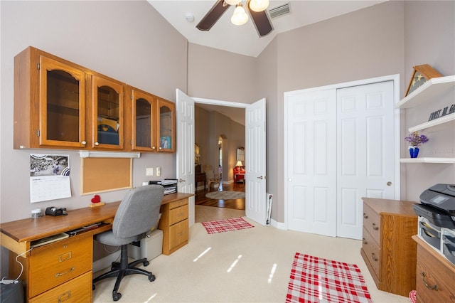 home office with light carpet and ceiling fan