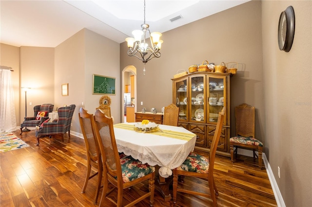 dining room with dark hardwood / wood-style flooring and a chandelier