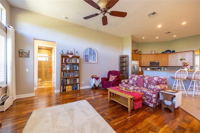 living room with dark wood-type flooring and ceiling fan