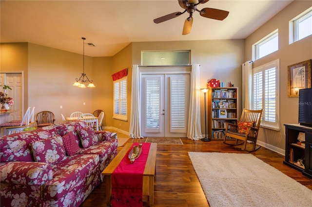 living room with dark wood-type flooring and ceiling fan with notable chandelier